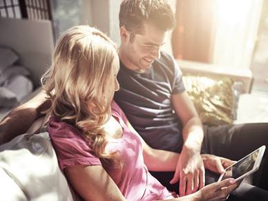 Couple sat together reading an iPad
