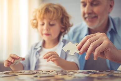 grandfather and boy play jigsaw