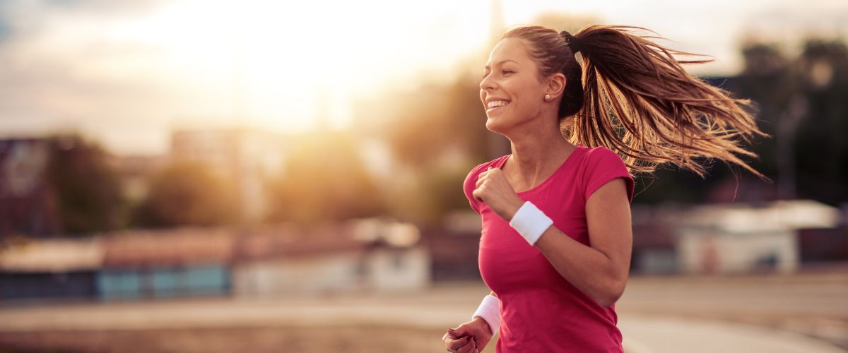 Motivated woman running in pink top 